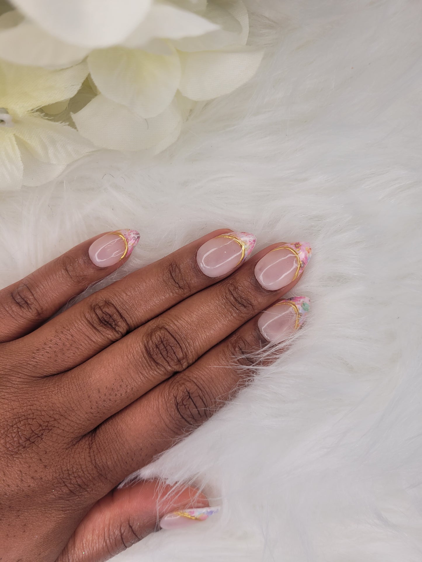 Hand with pink nail polish on a white background