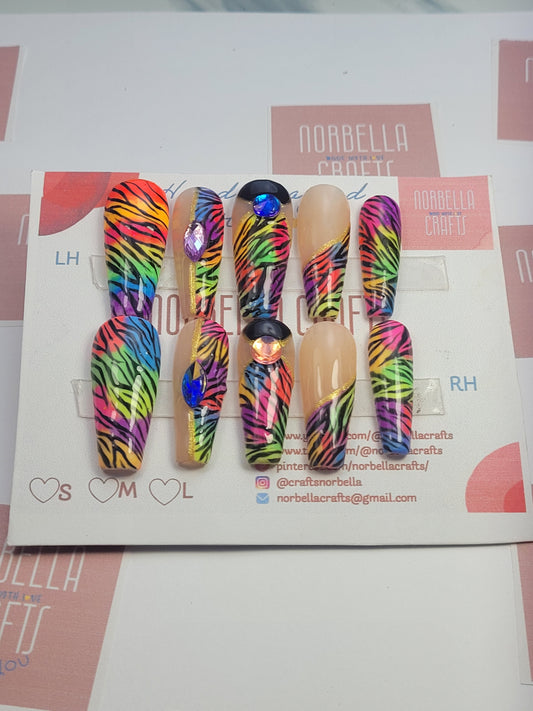 A picture shoiwing the custom press on nails by Norbella crafts - Rainbow Zebra Madness