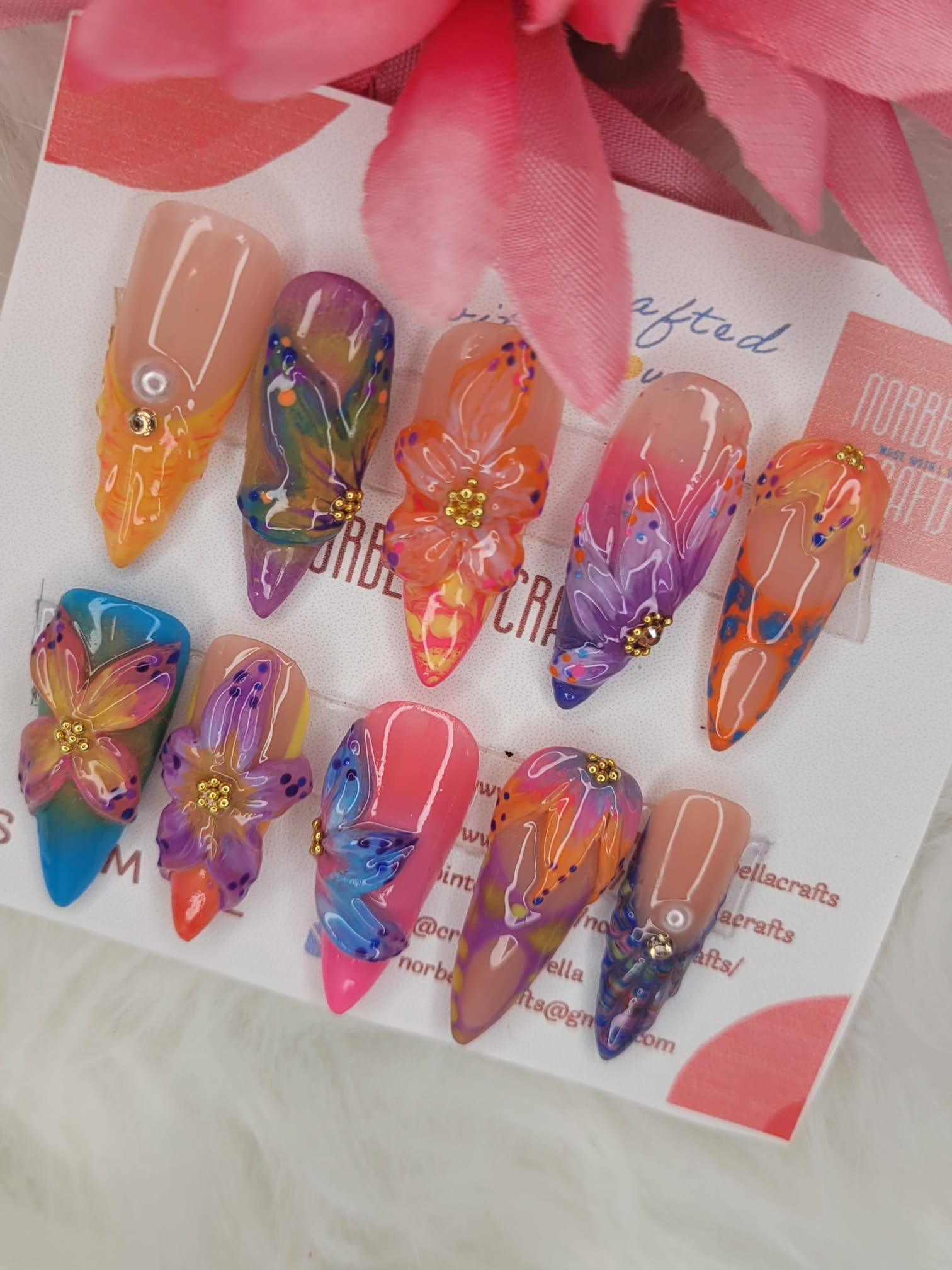 Colorful nail art designs on a white card with floral patterns.