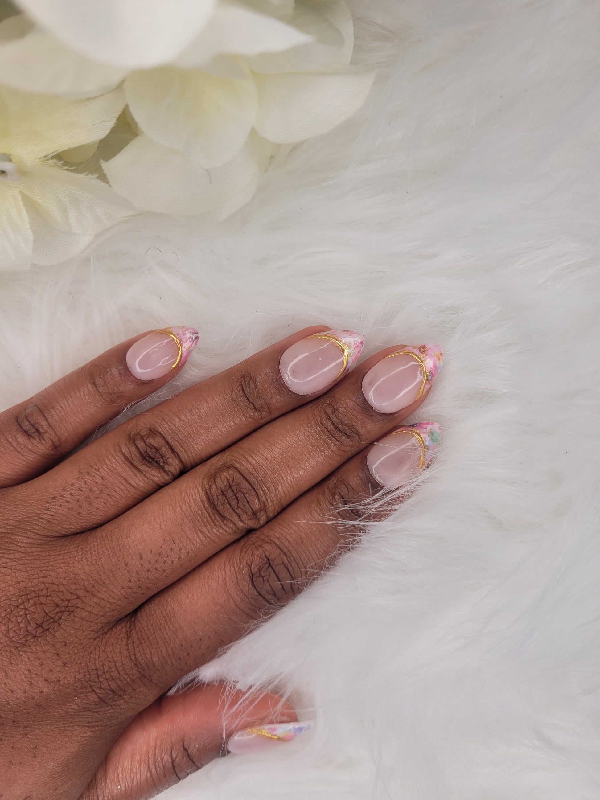 Hand with pink nail polish on a white background
