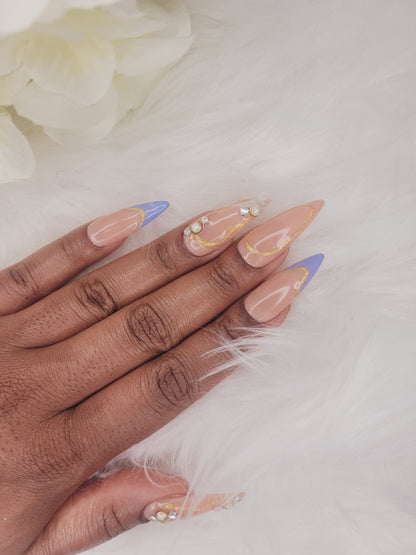 Picture of woman posing left hand and displaying blue french tip presson nail design