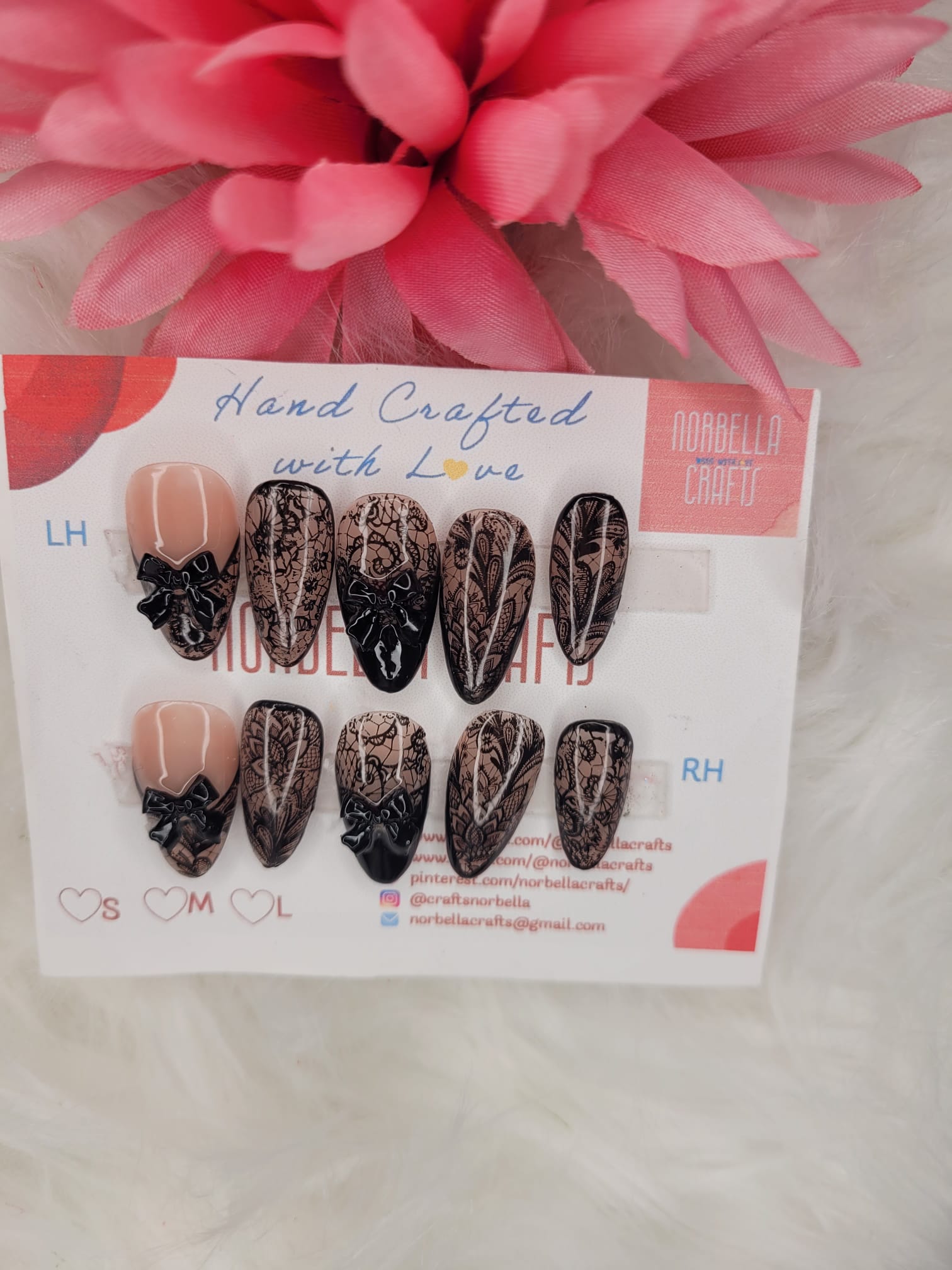 Set of handcrafted nail art designs on a branded card with a pink flower in the background.