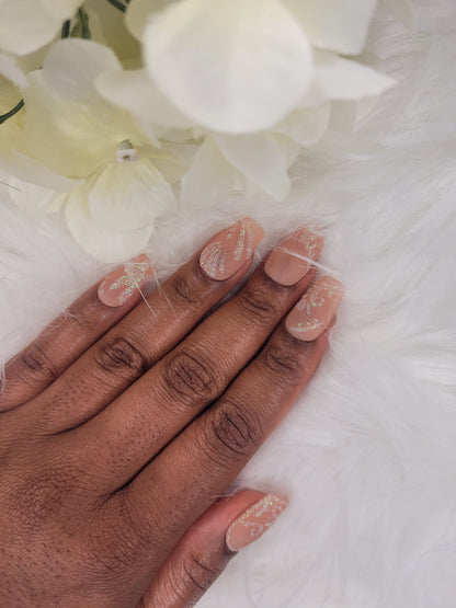 Hand with nude nail polish , glitter design on a white background with flowers