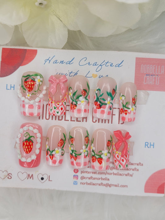 Set of nail art designs with strawberries and flowers on a branded card.
