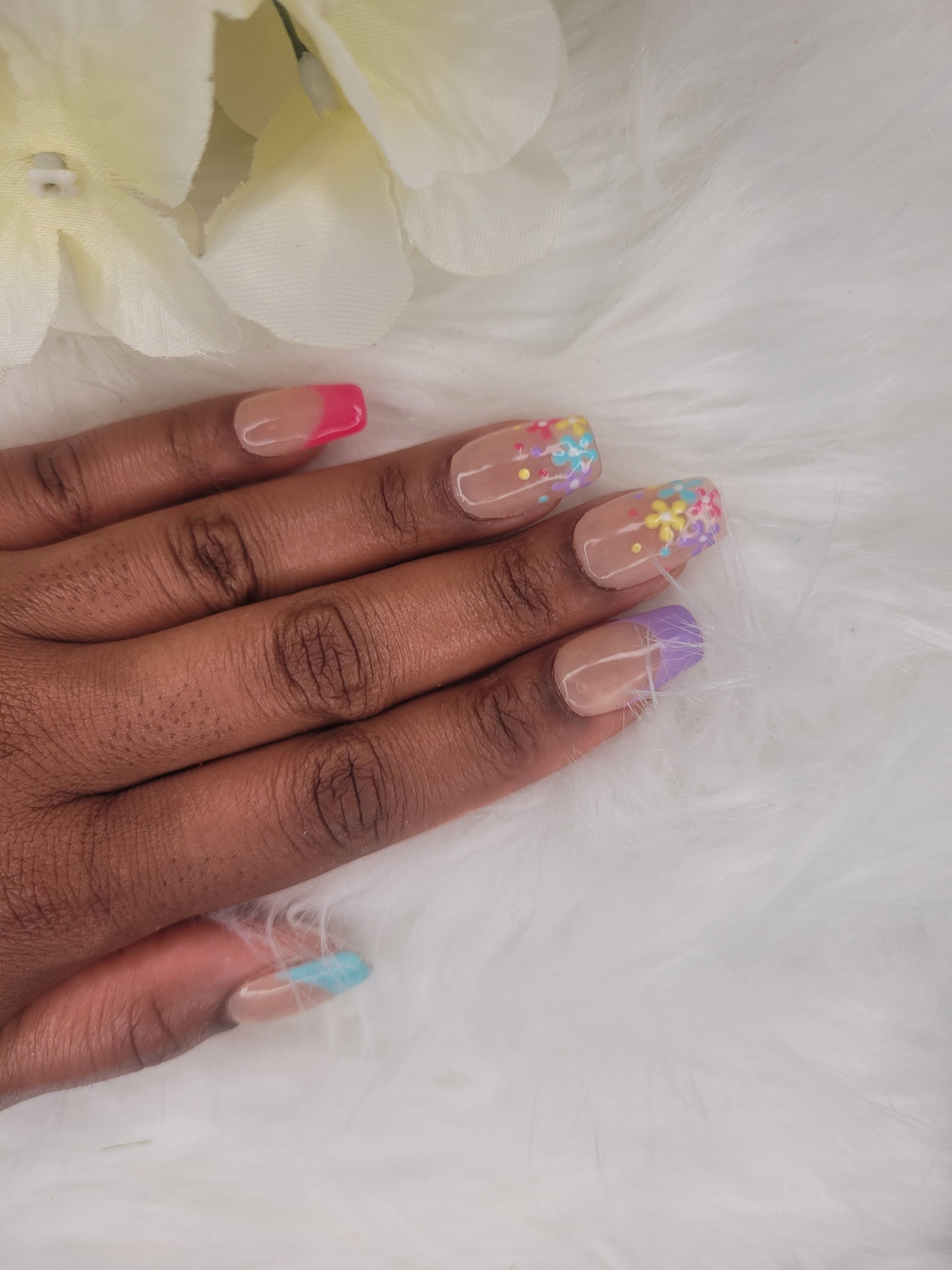 Hand with colorful nail art on a white background