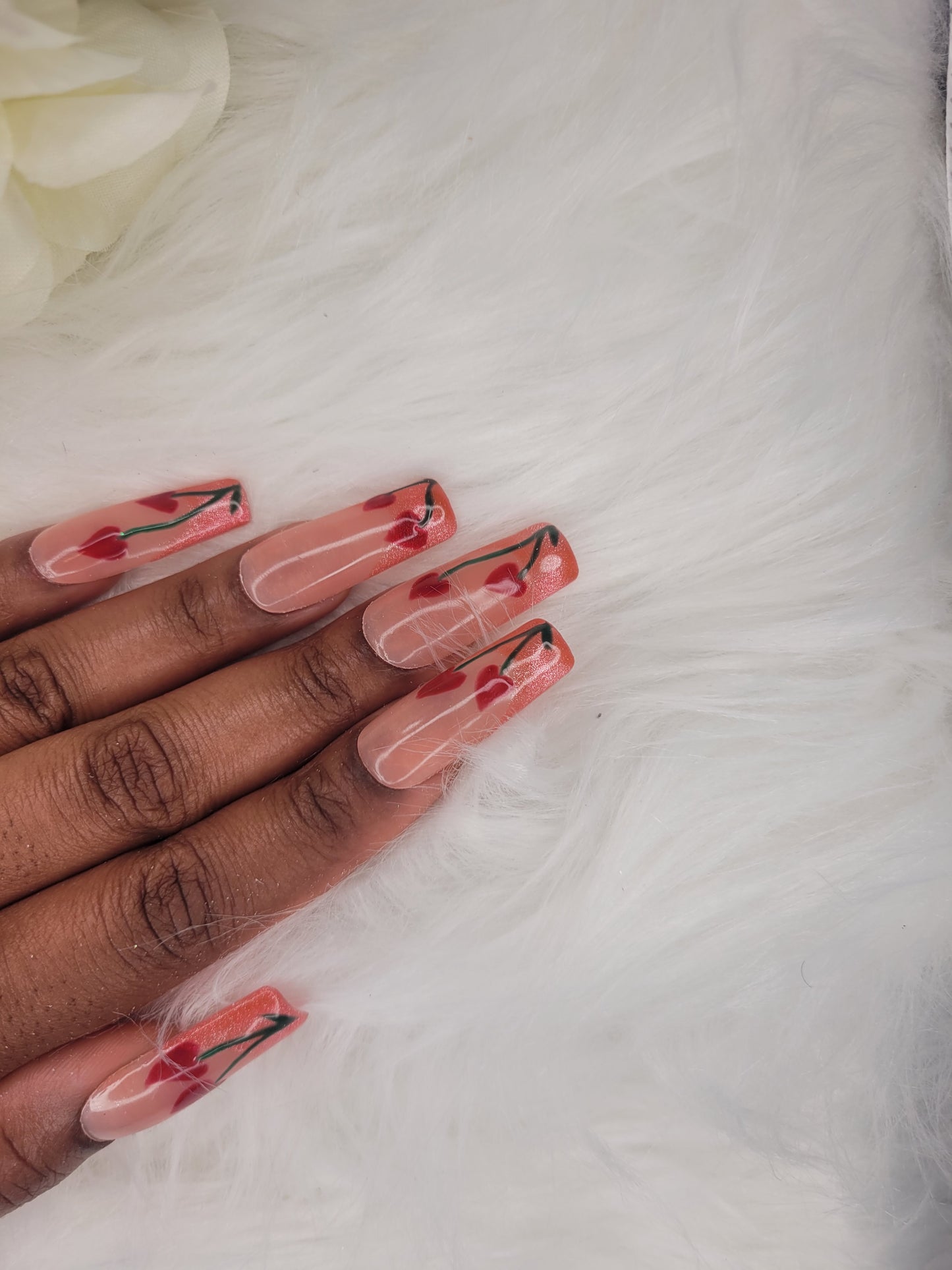 Hand with red and black nail art on a white background